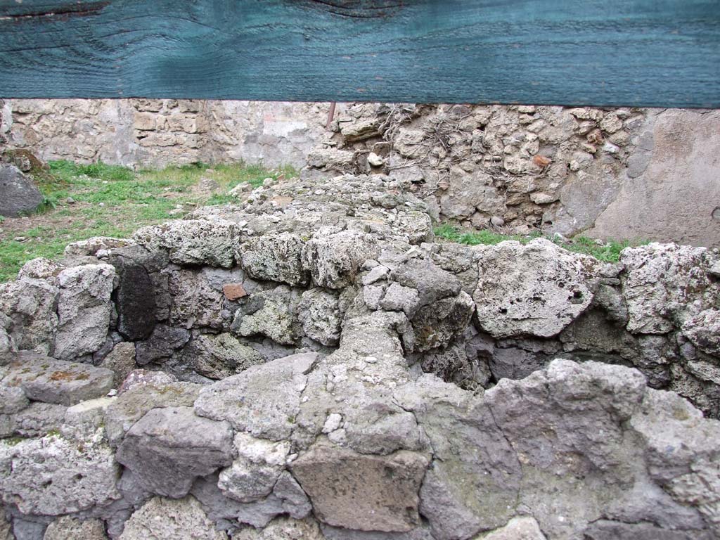 VI.16.2 Pompeii. December 2007.
Looking north across two-sided podium or counter, showing holes for two of the three urns, in the front part.
According to Sogliano, the receding part of the counter was very damaged when found.
The outside surface of the rear part was covered with stucco painted in red; the upper part had fragments of slabs of marble embedded into it.
See Notizie degli Scavi di Antichità, 1906, (p.345).