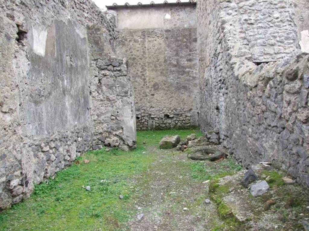 VI.16.5 Pompeii. December 2007. Looking west across shop towards rear room. According to Sogliano in NdS, when first excavated the walls were unadorned. Leaning against the right of the north wall were the remains of a large masonry feature with two steps before it.
To the right of this same and really in the north-east corner, there seemed to be seen the remains of a fusorium. Towards the other side of the same wall, there was a circular lava cistern mouth, (centre right of photo). See Notizie degli Scav idi Antichità, 1906, (p.350, and plan on p.346).