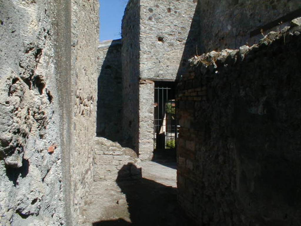 VI.16.38 Pompeii. September 2004. Looking east along corridor U from rear entrance. Looking east to steps to upper floor, room V, and doorway to room F, north-west portico.