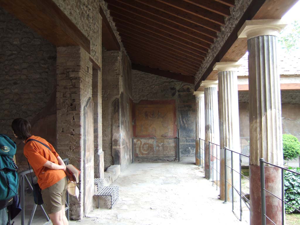 VI.16.7 Pompeii. May 2006. Room F, east portico. Looking south towards the lararium.
Nearest on the east wall is the doorway to room G.
Next is the entrance to the long, tall, narrow area 01 with metal steps.
This had the stairs to the upper floor over room G and the shop at VI.16.6.
The third entrance with a stone sill is the open area 03 that contained a cupboard.