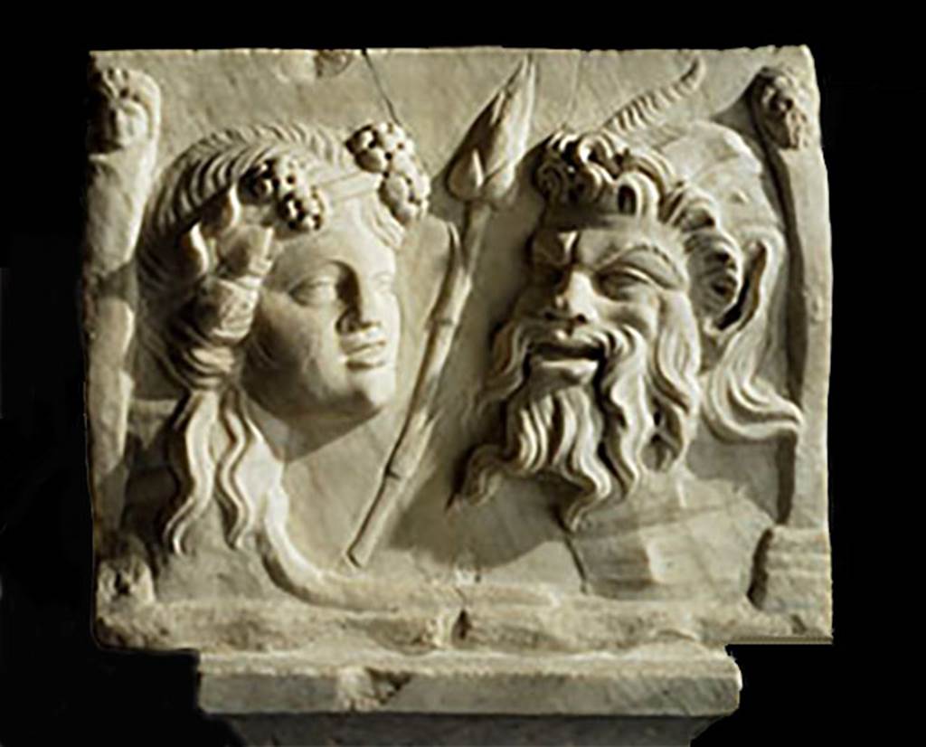 VI.16.7 Pompeii.
Two heads or masks (recognised as an ivy-wreathed maenad one of the female followers of the god Bacchus, and of the god Pan recognised by his goat horns) on reverse side of rectangular marble relief of satyr and Silenus, from south-east corner of peristyle garden. Found 1904.
SAP inventory number 20460.