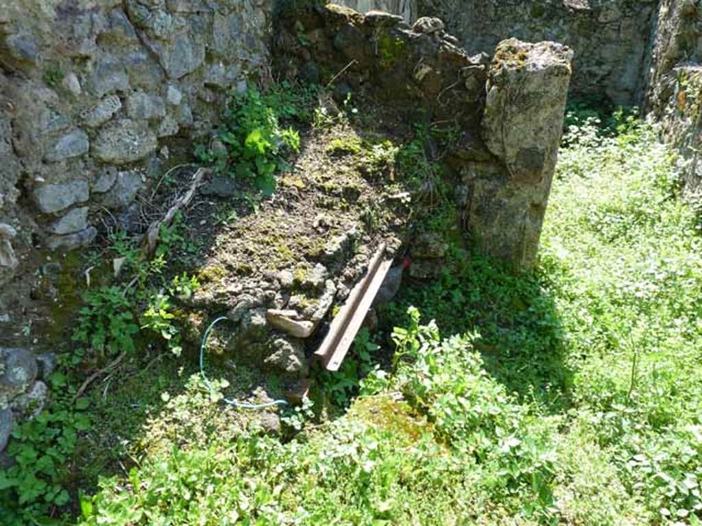 VI.16.11 Pompeii. May 2010. Remains of kitchen hearth and doorway to cubiculum.
According to NdS, at the western end of the corridor was a hearth with a masonry stove.
The hearth, which was empty underneath, had its upper part formed by four tiles.
