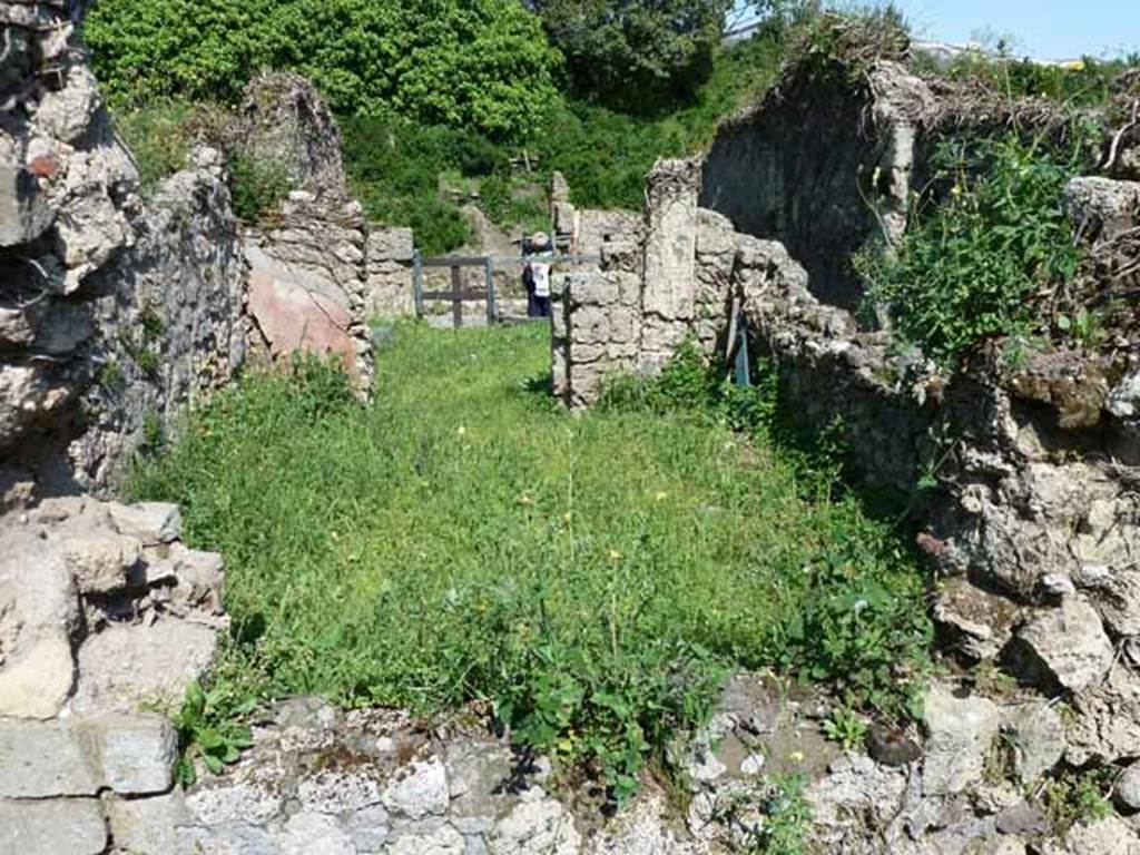 VI.16.11 Pompeii. May 2010. Looking east through site of window across large rear room, towards shop and entrance on Via del Vesuvio.