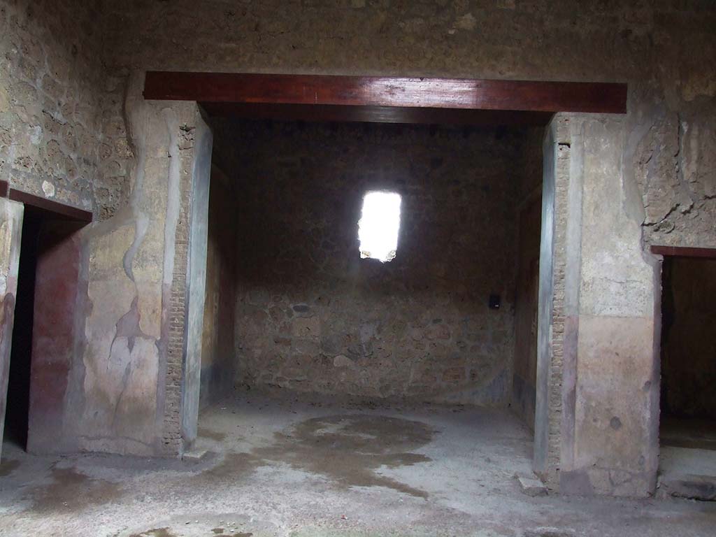 VI.16.15 Pompeii. December 2006. Doorway to room F in centre of south wall of atrium.
According to NdS, on the south side of the atrium opened room F almost in its entire width.
It had two black background painted jambs, on which were vertical bands of white, yellow and red.
The floor was of rough cocciopesto.
The south wall was entirely destroyed, while the west and east walls were well preserved.
Sogliano thought the room was probably used as a triclinium.