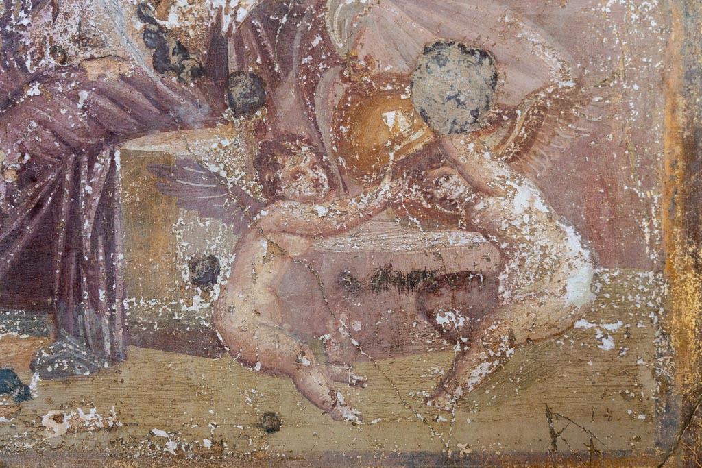 VI.16.15 Pompeii. January 2024.
Room G, detail of Cupids playing with helmet of Mars, from central painting on north wall. Photo courtesy of Johannes Eber.