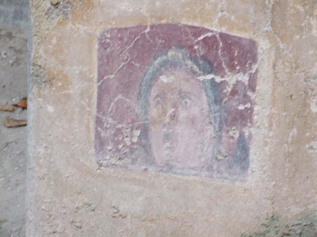VI.16.15 Pompeii. December 2006.
Atrium B, between doorway to room E and room D at base of wall. Detail of wall painting of face or mask.