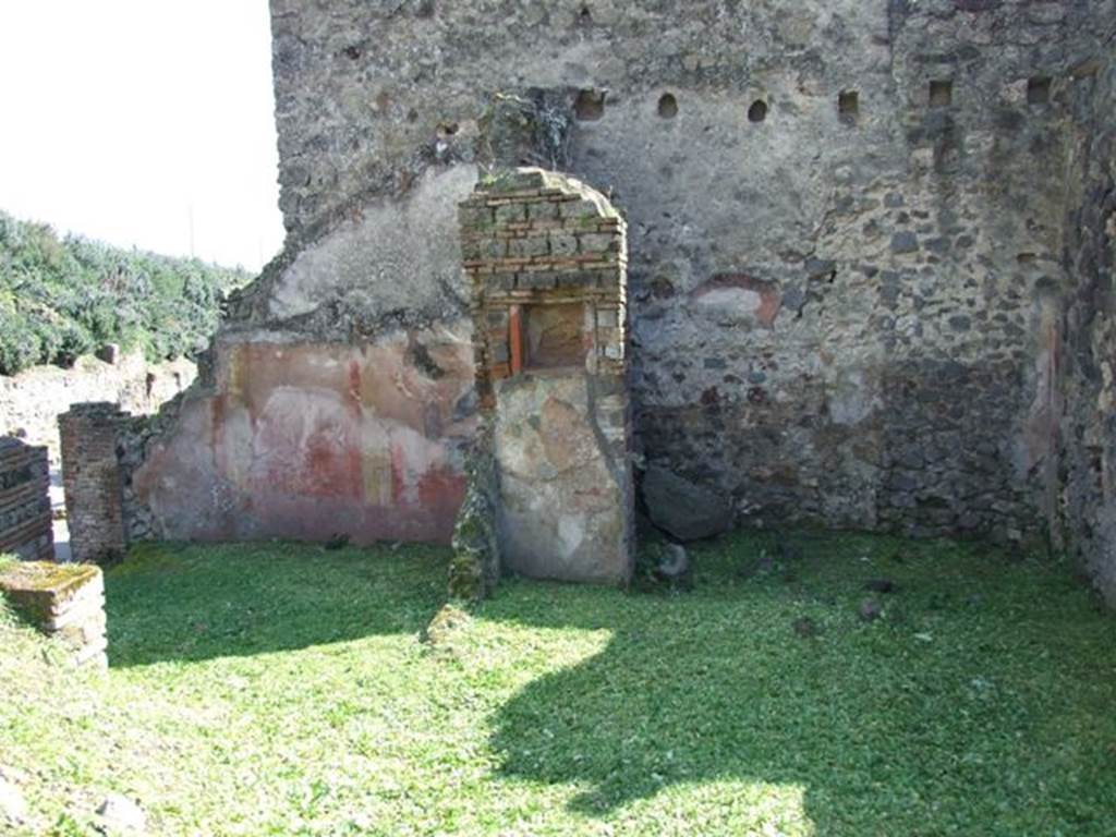 VI.16.20 Pompeii. March 2009. Looking south through site of doorway in north-west corner of room, (centre left) leading from other linked rooms. South painted wall of room on left of picture, with collapsed west wall of room. The red south wall, still shows signs of the painted yellow pilaster decoration.
