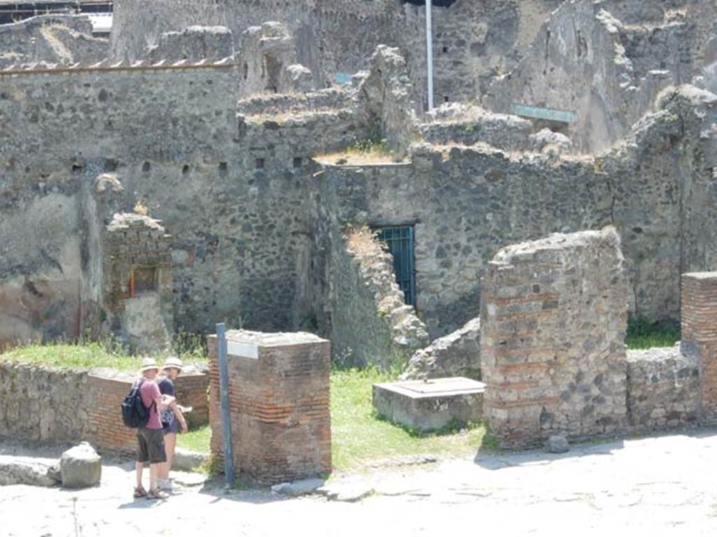 VI.16.21 Pompeii. May 2015. Entrance doorway with two tourists about to enter. VI.16.22 is in the centre of the photo. Photo courtesy of Buzz Ferebee.