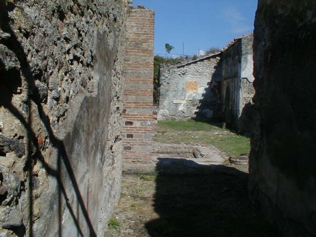 VI.16.26 Pompeii. September 2004. Looking east from entrance corridor A, across to atrium B.
According to NdS, the floor of the atrium was of cocciopesto.
The walls of the atrium had a high plastered dado (intonaco laterizio) and above this was a white plaster.
There was an impluvium in the centre and a large portico supported by a double pilaster and columns.
In the north-west corner of the impluvium was the pilaster to support the roof of the portico, and in the south-west corner was one of the two columns.
The other column was not far from the north-east corner of the impluvium.
The pilaster was made of rows of bricks and cut tufa in the manner of bricks.
The remains of the column to the west were all brick, while the other was made of brick and limestone.
See Notizie degli Scavi di Antichità, 1908, (p.183-192).