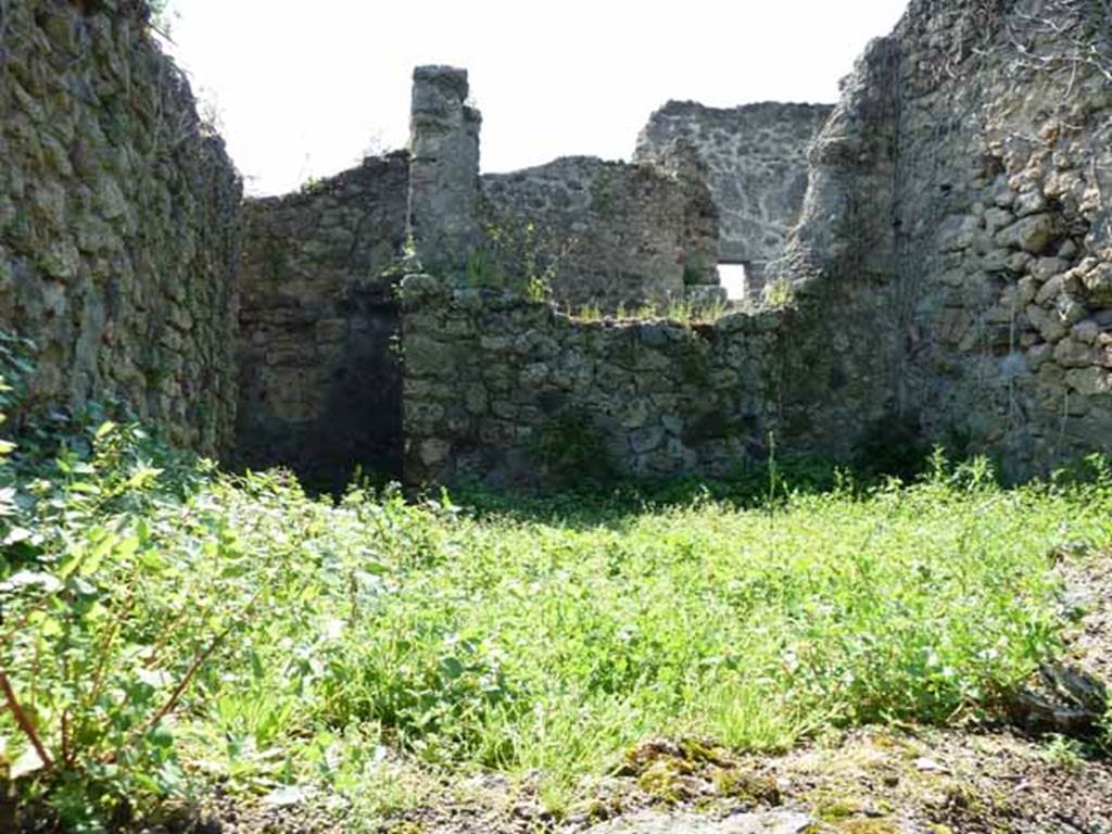 IV.16.35 Pompeii. May 2010. Rear room, kitchen I, on the east side. Looking west from VI.16.11. The doorway into the kitchen from the corridor is in the rear (west) wall on the left of the picture. Sogliano’s description was written as arriving into the kitchen from this corridor. Our picture was taken from the other side of the room.
According to NdS, corridor G turned at right-angle to the north, and then again at right-angle to the east, where it immediately opened into the kitchen, room I.
The hearth “c” leaned to the left end of the east wall, (right front of this photo).
It had roof tiles on its edge and an arched empty space below.
Perpendicular to the south wall were two parallel walls, which formed two small rooms, (area on the left of this photo).
Room “d” was the latrine.
Room “e” was a repository.
See Notizie degli Scavi di Antichità, 1908, (p.359-363)