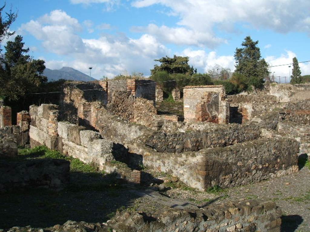 VI.17.4 Pompeii. December 2004. Looking north-east from rear, looking across the second room on west side at rear of bar (with lava threshold) towards the corridor leading north towards VI.17.1. Seen on the right is our photograph below, described as “room on the north side at the rear of VI.17.3”, a triclinium according to Fiorelli.