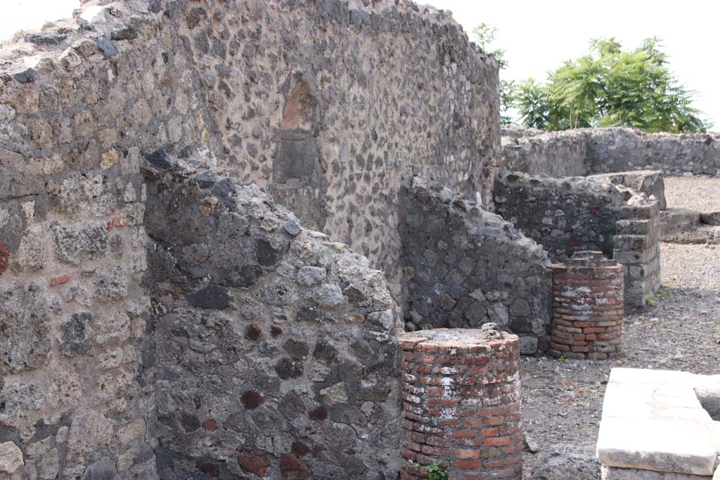 VI.17.4 Pompeii. September 2021. Looking west along south wall with niche and two masonry columns. Photo courtesy of Klaus Heese.