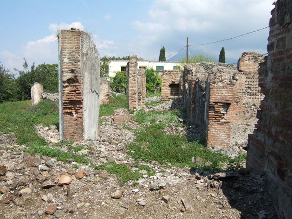 VI.17.32 Pompeii. May 2006. Looking north along remains of east side of rear peristyle area, taken from VI.17.41.
According to Jashemski, steps at each entrance (VI.17.32 and 36) led to an atrium: immediately at the rear of these there was a large peristyle garden.
This was enclosed by a portico on 4 sides.  
In the middle of the garden was a pool with a fountain, with little steps leading into the pool, but this was no longer in existence when Breton wrote.
See Jashemski, W. F., 1993. The Gardens of Pompeii, Volume II: Appendices. New York: Caratzas. (p.166 with plan)
See Breton, Ernest. 1870. Pompeia, Guide de visite a Pompei, 3rd ed. Paris, Guerin. (p.266)

According to Pagano �
VI.17.32 and 36. Casa di Giulio Polibio.
�Vi si ascende per due ingressi communicanti con due sale o vestibuli, che tengono le veci dell�atrio. Tutti e due i vestiboli mettono in un gran peristilio circondato da un portico d�ordine corinzio, e avente nel mezzo una fontana; sembra che le arcate del portico potessero chiudersi con trlai di vetro.�
(translation:
"Here, one ascends to two entrances communicating with two rooms or vestibules, which take the place of the atrium. Both vestibules lead into a great peristyle surrounded by a Corinthian portico, and having a fountain in the middle; it seems that the arches of the portico could have been closed with glass frames."
See Pagano, N. (1868).Guida di Pompei. 2nd ed. (p.58-59)
)
