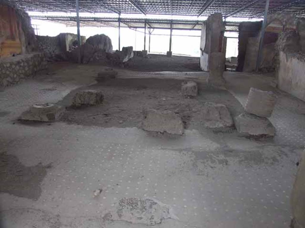 VI.17.41 Pompeii. May 2010. Looking west across atrium.
The flooring was made of a mosaic of black tesserae arranged with the dots of large white tesserae in lines.
A broad band of white tesserae marked the edges of the impluvium.
On the four corners of the impluvium would have been brick columns covered in stucco.