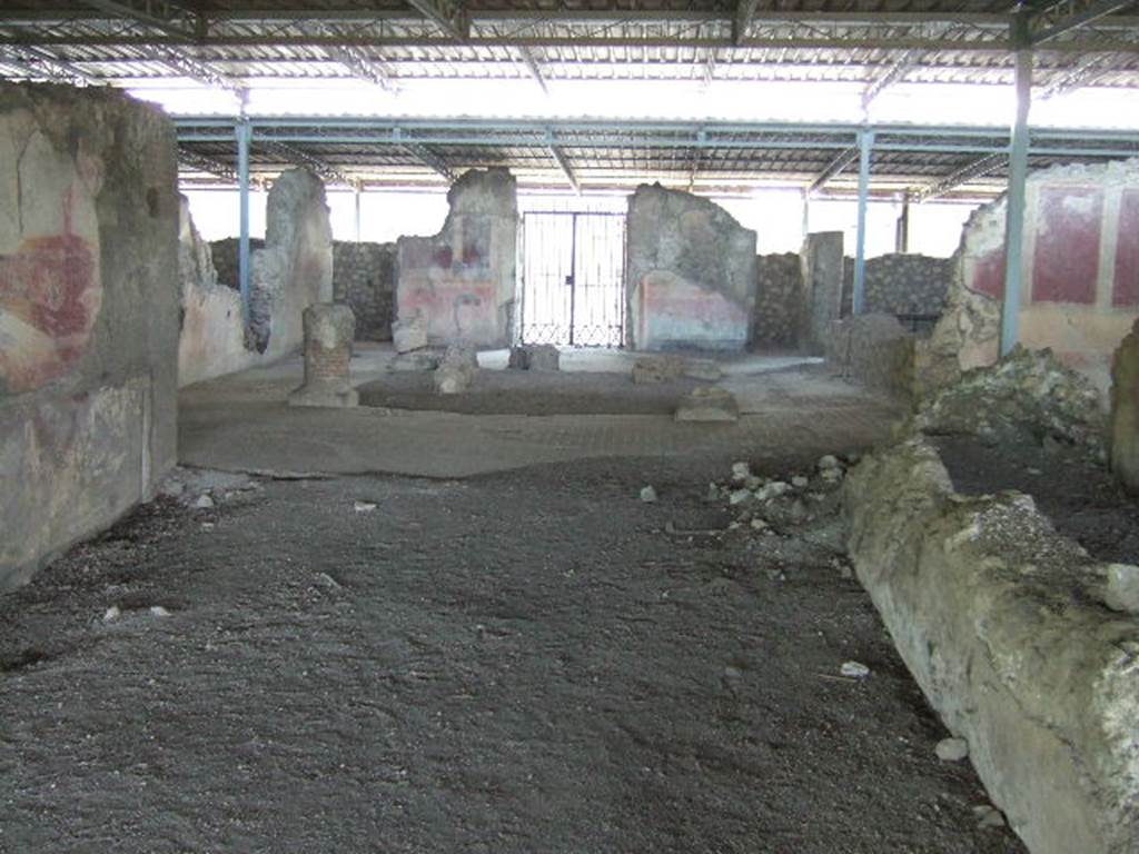 VI.17.41 Pompeii. May 2006. Looking east from rear of tablinum towards atrium and entrance.
According to PPM, this room has been very badly preserved, it was damaged during the Bourbon excavations when the south wall of the neighbouring room was cut away, and was possibly deprived of its mosaic floor at that time.
On the north wall, the only wall that retains any decoration, the zoccolo was red and in it, in the centre of the wall a female figure can be seen.
In the middle area of the wall, resting his right foot on the base of a podium was a huge figure and nearby the bow of a ship.
The zoccolo appeared to be more sunken into the wall than the rest of the wall, and with its sharp break from the painting of the middle area, may have been of an earlier wall decoration.