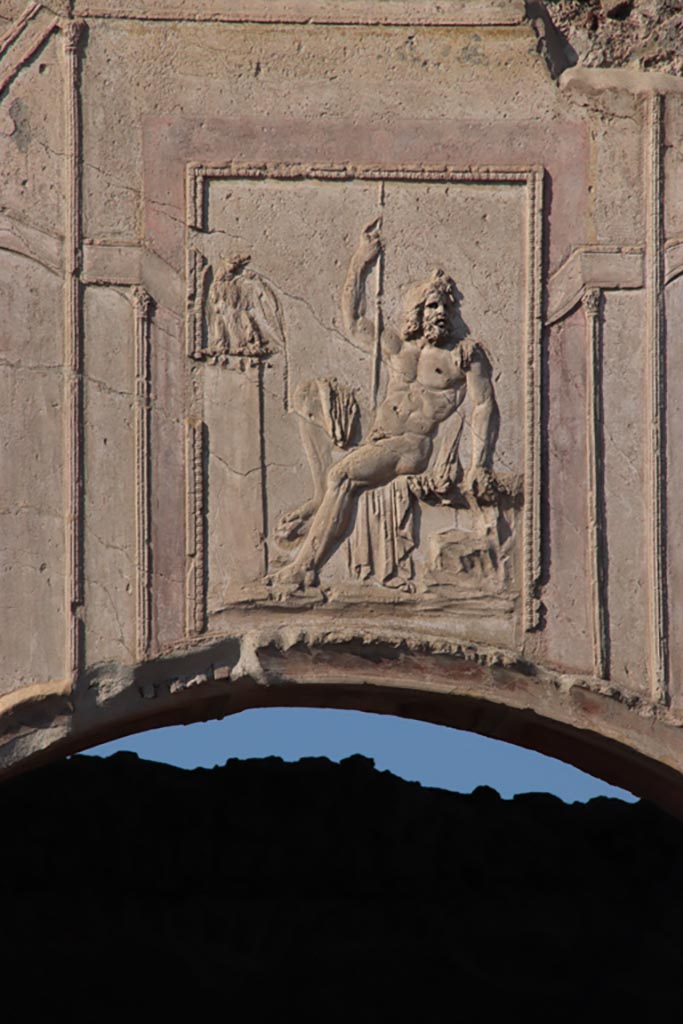 VII.1.8 Pompeii. October 2022.
Stucco relief of a seated Zeus, above arch of nymphaeum F. Photo courtesy of Klaus Heese.