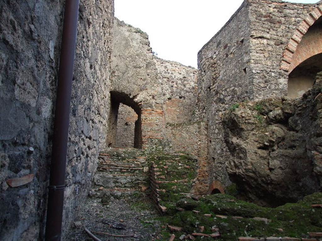 VII.1.8 Pompeii. December 2006. Praefurnium 7 with steps to water tanks 6 and entrance VII.1.15 through arch.