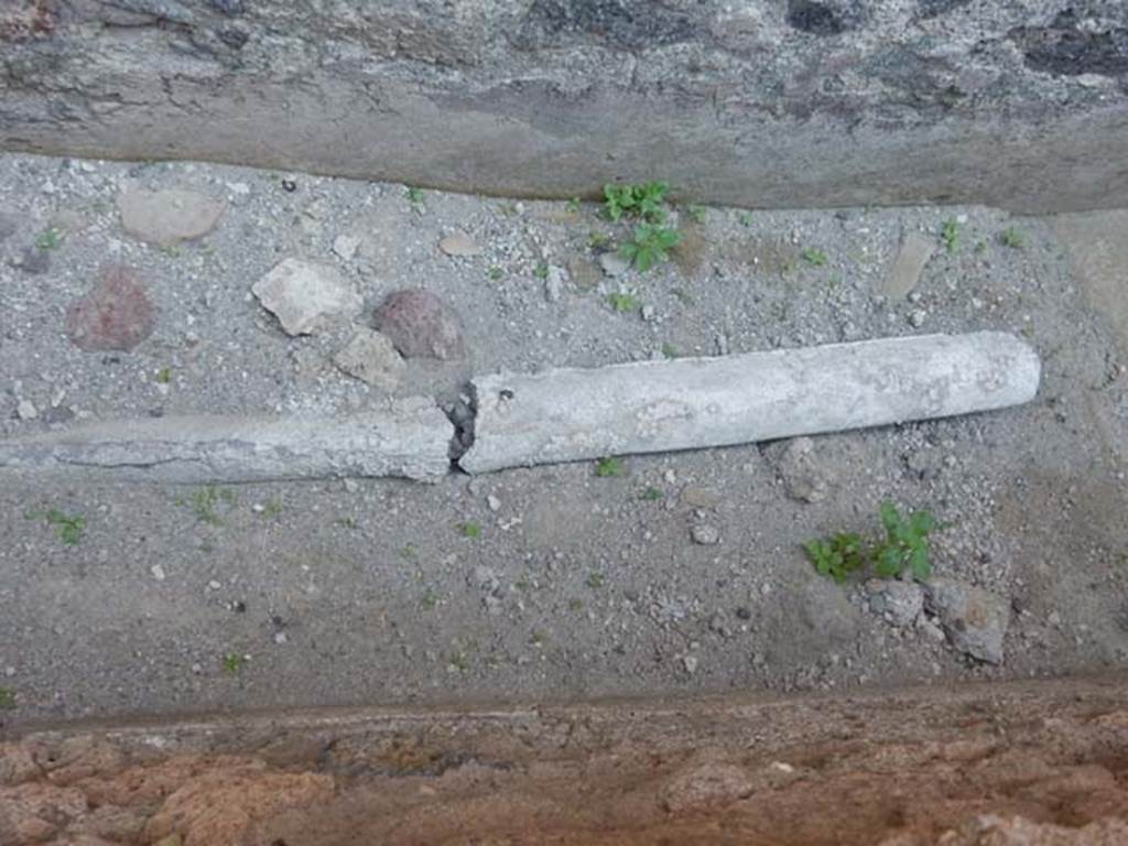 VII.1.17 Pompeii. May 2017. Lead pipe on floor of narrow passage on south side of room 21 of VII.1.47, probably part of VI.1.17
Photo courtesy of Buzz Ferebee.