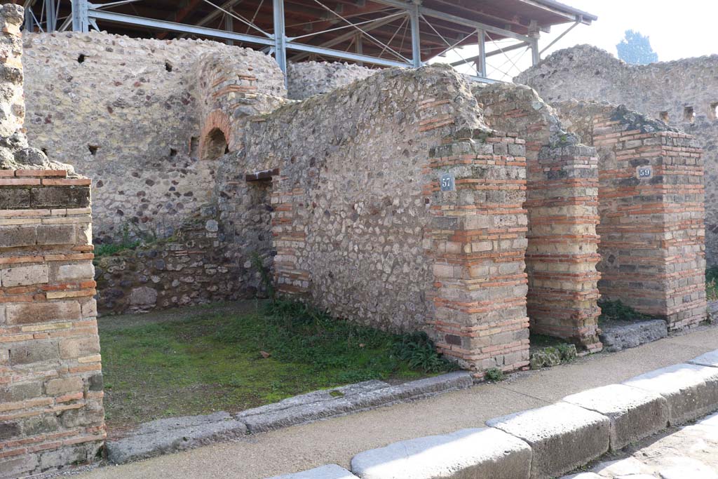 VII.1.57, Pompeii, on left. December 2018.
Looking east on Vicolo del Lupanare towards entrance doorways. Photo courtesy of Aude Durand.