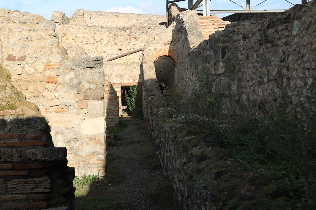 VII.1.58, Pompeii. December 2018.
Looking north from end of entrance at VII.1.58, a corridor at rear of shops VII.1.52-VII.1.57 with Stabian Baths at rear.
Photo courtesy of Aude Durand.