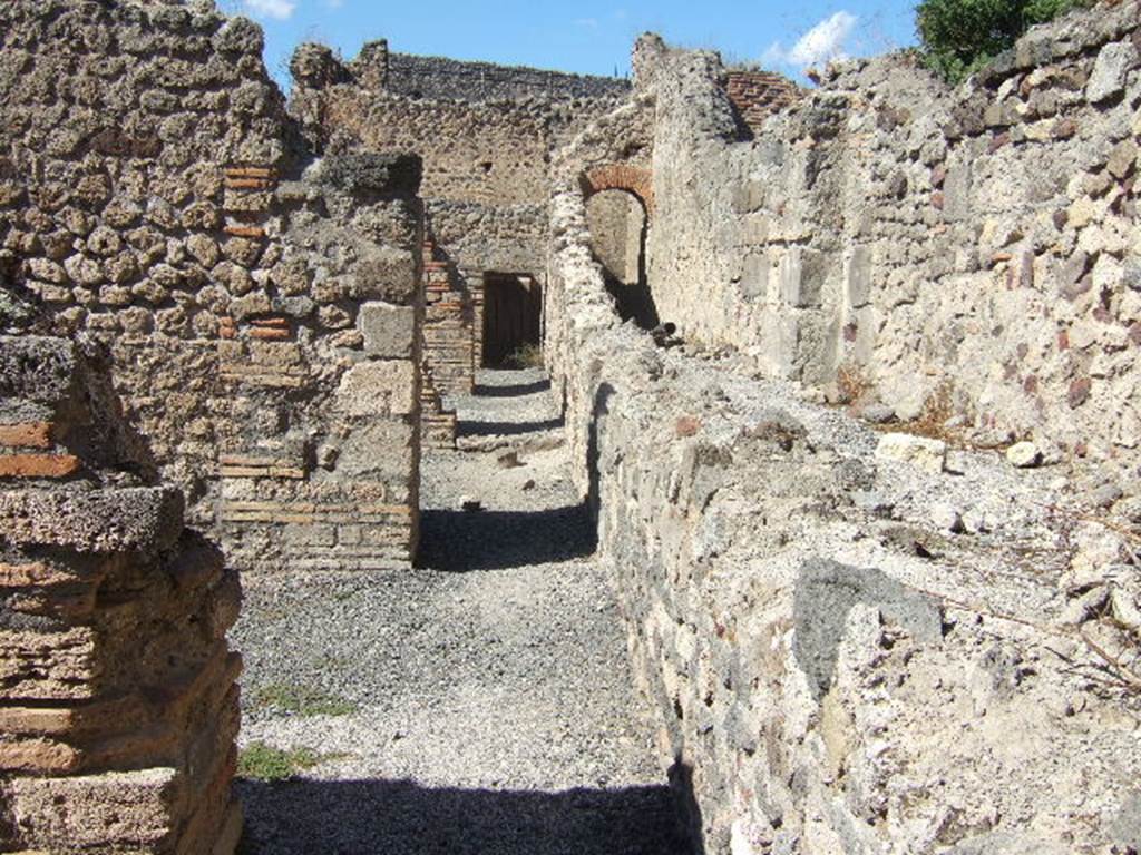 Corridor at rear of shops VII.1.52-VII.1.57 with Stabian Baths at rear.
Looking north from end of entrance of VII.1.58, Pompeii. September 2005.