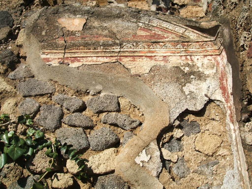 VII.2.6 Pompeii. December 2004. Stucco decoration in cubiculum with vaulted ceiling in north-east corner of atrium. This cubiculum had a red zoccolo subdivided into panels, in the central panel was a plant with long leaves.
In the middle area of the wall, it was painted white, showing two panels divided by a narrow compartment with a candelabra painted between them. The upper area of the wall was also white, subdivided into squares edged in red. The stucco edged vault of the room was above this.