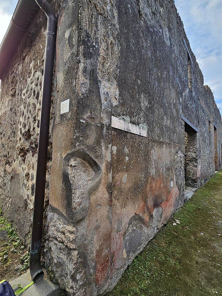 VII.2.16 Pompeii. November 2024.
Inner west side of entrance doorway and exterior street wall on west (right) side of entrance doorway between VII.2.16 and VII.2.17.
Photo courtesy of Annette Haug.