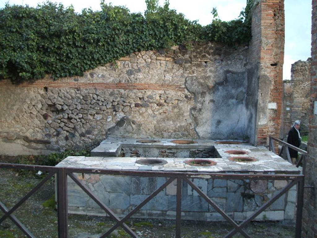 VII.2.32 Pompeii. December 2005. Entrance on Vicolo Storto. Looking east towards the four-sided marble clad counter with seven urns. To the right is the entrance from VII.2.33 on Via degli Augustali.