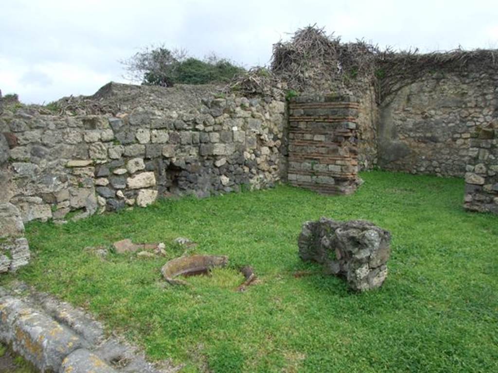 VII.3.4 Pompeii. March 2009. East side of shop, looking south east across site of counter, with remains of 3 urns.