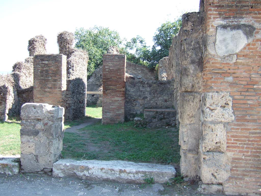 VII.3.11 Pompeii. September 2005. Looking south at entrance with steps to upper floor.
According to Helbig, on the outside wall between Strada della Fortuna 26 and 25, (VII.3.11 and VII.3.10),
on the right, there was a faint trace of a painted Lar with a situla (a bronze vessel).
See Helbig, W., 1868. Wandgemälde der vom Vesuv verschütteten Städte Campaniens. Leipzig: Breitkopf und Härtel. (no: 93)
According to Frohlich, the painting of a Lar with situla was found on the façade, exact position unknown. Now destroyed.
See Fröhlich, T., 1991. Lararien und Fassadenbilder in den Vesuvstädten. Mainz: von Zabern. (p. 325, F47)