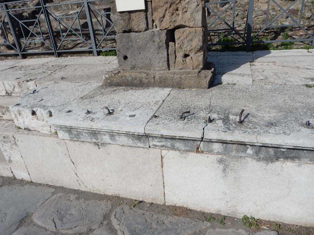 VII.4.1 Pompeii. June 2019. Looking east to detail of centre of the podium between the steps. This would have had an iron fence around its edges.
Photo courtesy of Buzz Ferebee.