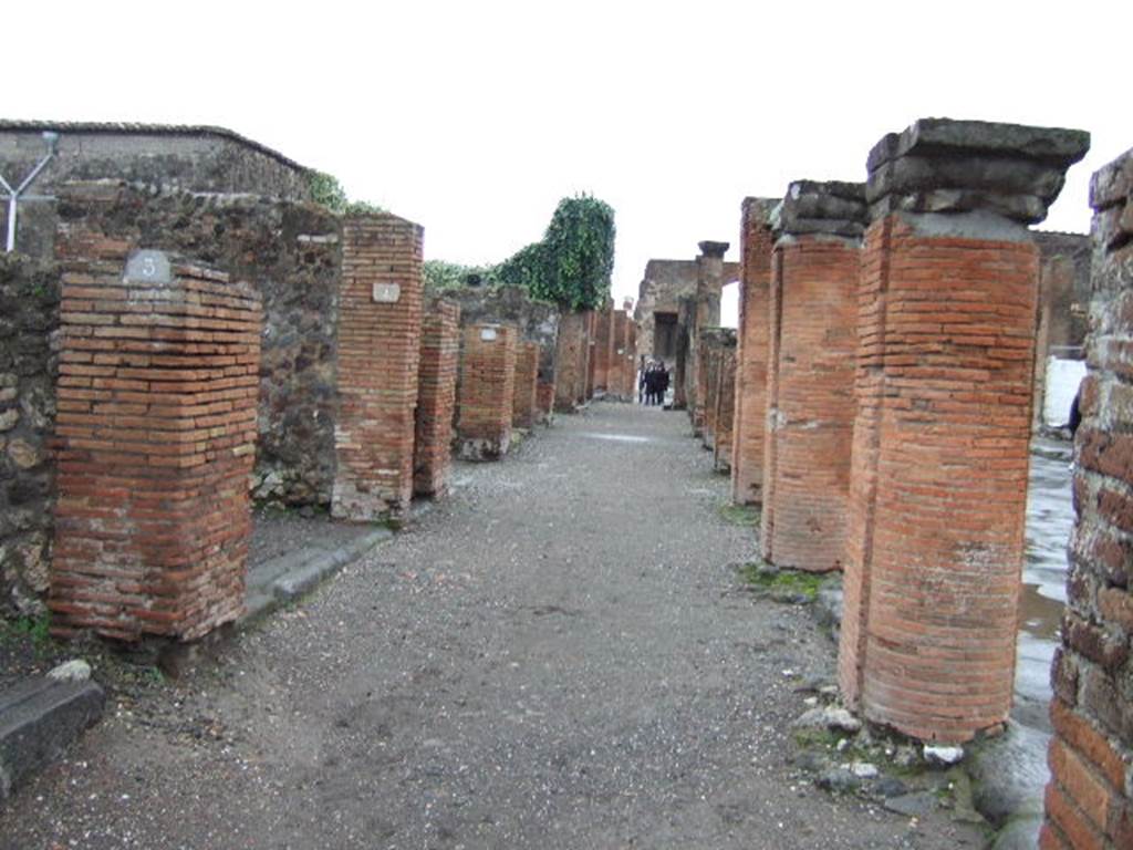 VII.4.3 and VII.4.4 Pompeii. December 2005. Looking south along portico outside shops on Via del Foro.