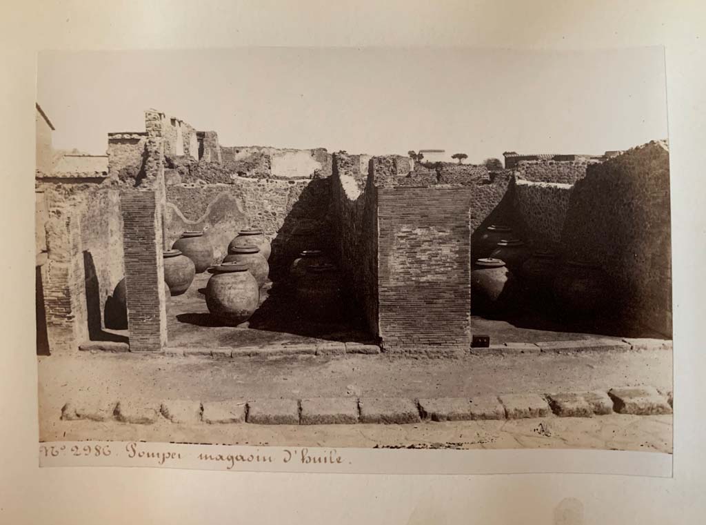 VII.4.13, in centre left, and 14, in centre right.
Album by M. Amodio, c.1880, entitled “Pompei, destroyed on 23 November 79, discovered in 1748”.
According to the writing on this photo, this was a warehouse (storehouse) for oil. Photo courtesy of Rick Bauer.