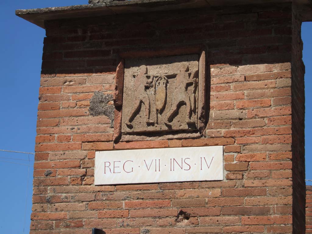 VII.4.16 Pompeii. September 2005. West corner pilaster.
Plaque of Nucerian stone showing relief of two men carrying an amphora on a wooden pole stretched across their shoulders.