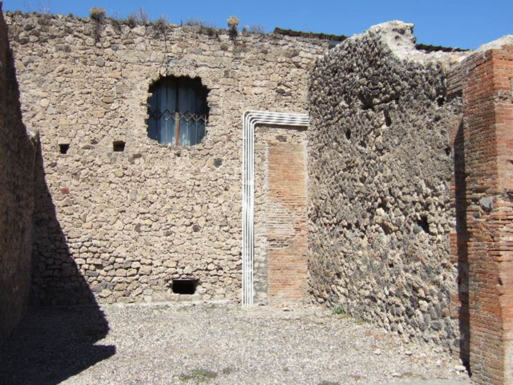 VII.4.20 Pompeii. September 2005. North and East wall. At the rear of the north wall of this shop room would have been the dwelling. The Lararium painting below, was found on the north wall of the kitchen of the dwelling.