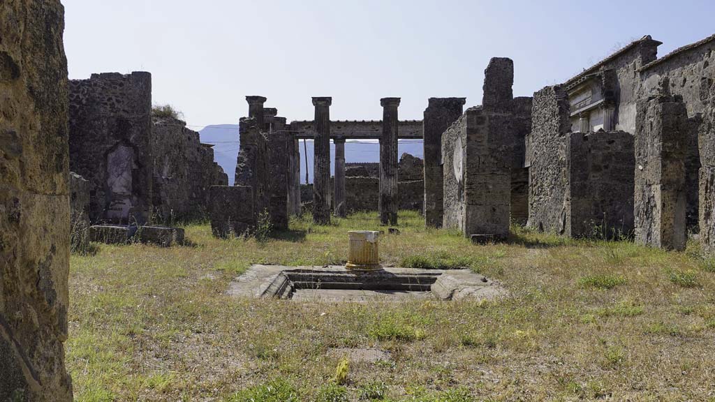 VII.4.57 Pompeii. August 2021. Looking south across atrium from entrance doorway. Photo courtesy of Robert Hanson.
Secondo Avellino -
“Dall’androne descritto si passa nell’atrio sicuramente tuscanico, nel mezzo del quale, abbenché un poco più a destra di chi entra, vedesi l’impluvium con cornice in giro di piperno. Avea esso nel mezzo un fonte, di cui rimane ancora il cominciato del tubo di piombo, ed i cui ornamenti di marmo verranno da noi descritti di poi.
Sul lato che guarda il tablinum è l’apertura del pozzo con un puteale striato di bianco marmo. E desso situato tra quattro piccole basi di marmo colorato, ciascuno delle quali ebbe un incavo già introdotta una zampa di leone pur marmorea, di una delle quali esiste un frammento. Sostenevano una mensa pur essa di marmo colorato, della quale anche si son trovati i frammenti. Convien credere che questa mensa fu distrutta, quando si mise in uso il puteale, situandolo così nello spazio, che essa occupava……….
I dipinti delle pareti dell’atrio sono anche semplicissimi, consistendo in uno zoccolo con iscompartimenti di varii colori.”
See Avellino, F. M. 
Descrizione di una Casa Pompejana Disotterrata in Pompeii nell’anno 1831, 1832, 1833 la terza alle spalle del tempio della Fortuna Augusta. Naples, 1837, (p.9-10)
(trans. According to Avellino -
 "From the entrance hall, one passes into the Tuscan atrium, in the middle of which, however a little more to the right of those who enter, you see the impluvium framed around with a Piperno stone cornice. In the middle it had a fountain, of which the beginning of the lead pipe still remains, and whose marble ornaments will be described by us below.
On the side overlooking the tablinum was the opening of the cistern-mouth with a white marble striped puteal.  It was situated between four small bases of coloured marble, each of which had a recess already introduced for a marble lion’s paw, of one of which there is a fragment. They supported a table also made of coloured marble, of which fragments have also been found. It is reasonable to believe that this table was destroyed when the puteal was put into use, thus placing it in the space it would have occupied..........
The painting on the walls of the atrium are also very simple, consisting of a zoccolo/plinth with compartments of various colours.")
