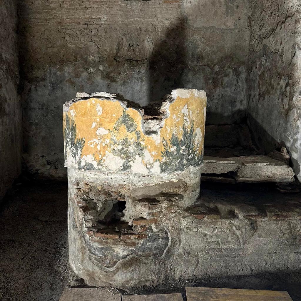 VII.5.8 Pompeii. March 2024. Caldarium 50, and labrum 52.
The masonry support of the labrum, with vegetal decoration, in the calidarium after restoration.
The calidarium was equipped with a small tub for immersion baths and the labrum of which only the masonry support of the tub remains.
The tepidarium and calidarium were both equipped with a floor with a cavity supported by small pillars (suspensurae) for the passage of hot air, which then also flowed into the walls equipped with hollow tegula mammata tiles. The floor of the calidarium was destroyed in the earthquake of 62 AD. and at the time of the eruption it was being renovated, as also demonstrated by a pile of mosaic tiles found in a corner of the room at the time of the excavation and still preserved on site.
See PAP E-Journal 02 – 8.3.2024, p. 5-6 fig. 9.
Photograph © Parco Archeologico di Pompei.