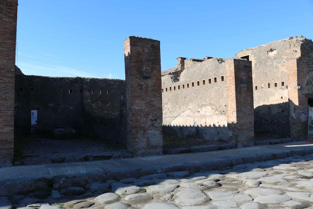 VII.5.21, Pompeii, on left. December 2018.
Looking west to shop entrances on west side of Via del Foro, VII.5.21/22/23. Photo courtesy of Aude Durand.