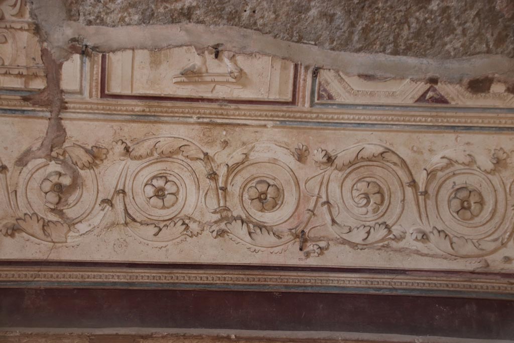 VII.5.24 Pompeii. October 2023.
Plaster stucco on west wall in south-west corner of tepidarium (37), (continued). Photo courtesy of Klaus Heese.