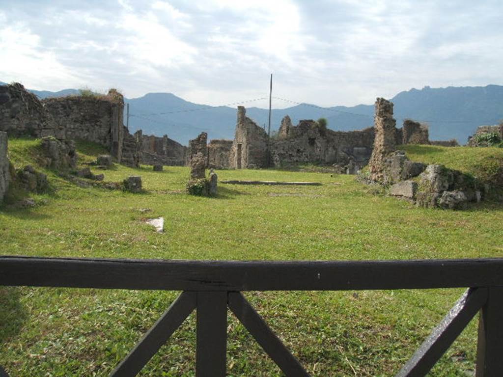 VII.6.8 Pompeii. May 2005. In the foreground behind the wooden gate, would have been the site of the shop at VII.6.8. In the background behind the shop would have been the house at VII.6.7.