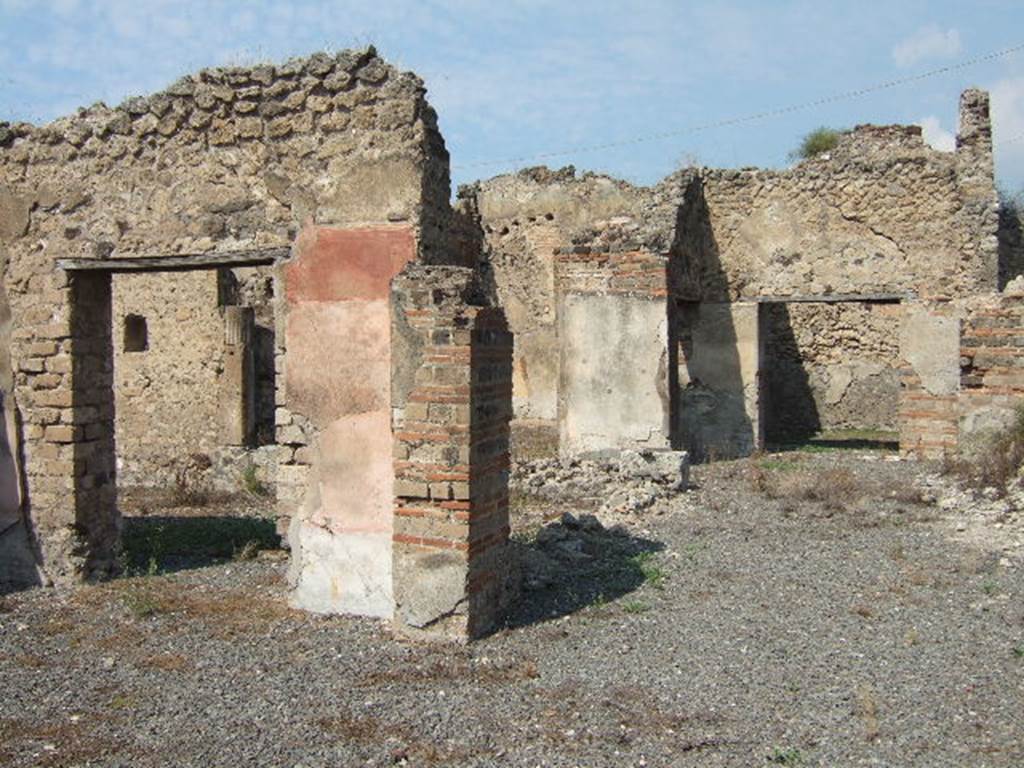 VII.6.30 Pompeii. September 2005. Looking north-west across room with doorway to the garden, on left. On the right of the photo, the destroyed east wall would have contained a niche. According to Boyce, in the east wall of the main room which was entered directly from the fauces was a delicately painted tall, rectangular niche. He thought this was a Lararium. The white background of the surrounding wall was divided by dark stripes into a series of rectangles. These rectangles were in imitation of a veneer of slabs of marble or of a wall built of rectangular blocks of stones.
See Boyce G. K., 1937. Corpus of the Lararia of Pompeii. Rome: MAAR 14. (p.67, no.292)
According to the Notizie degli Scavi, 1910, page 481, on the east wall …… a delicately painted niche, which served as a sacrarium.