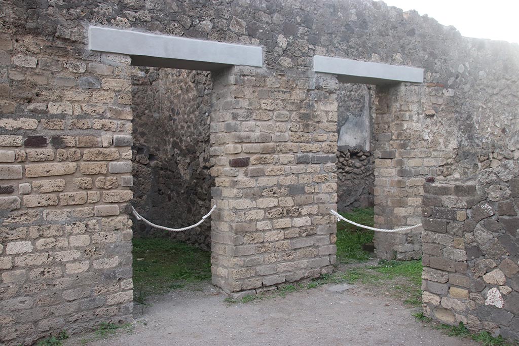 VII.7.2 Pompeii. October 2024.
South side of atrium, with doorway to room “d” on left, and room “i”, visible behind the wall, on right, in room “h”. Photo courtesy of Klaus Heese.