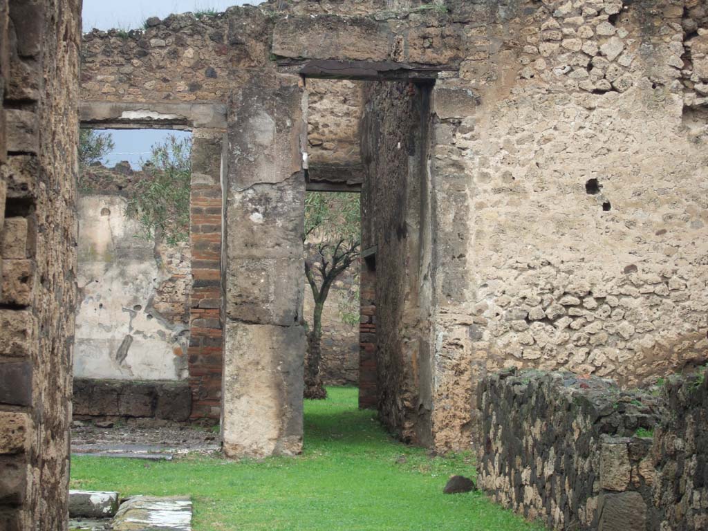 VII.7.2 Pompeii. December 2005. Looking north from entrance along corridor “l” (L) from atrium to peristyle, with tablinum “k”, on left.
According to Garcia y Garcia –
the house at VII.7.5, linked by the south portico at the rear of this tablinum, was hit by a bomb during the night of 24th August 1943.
During the night bombing on 13th September 1943, the secondary peristyle at VII.7.2 was hit.
Together with the felling of the six columns, the portico was totally destroyed as well as the three rooms on the west side.
Nearly all the paintings of the II and IV style that decorated the secondary and central tablinum and the room to the north-east of this peristyle, were lost.
See Garcia y Garcia, L., 2006. Danni di guerra a Pompei. Rome: L’Erma di Bretschneider. (p.112-114, including photos).