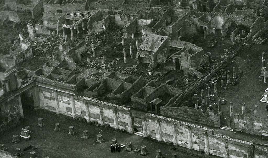 VII.7.2 Pompeii. 1944, detail taken from USAAF aerial photo.
Looking north-west across the Basilica and Via Marina, lower left in photo.
On the north side of the Via Marina, in the upper part of the photo, the house of House of Romulus and Remus (VII.7.10), and House of Tryptolemus (VII.7.5 and VII.7.2) can be seen on the west side of the Temple of Apollo, which is on the right.
Photo courtesy of Rick Bauer.