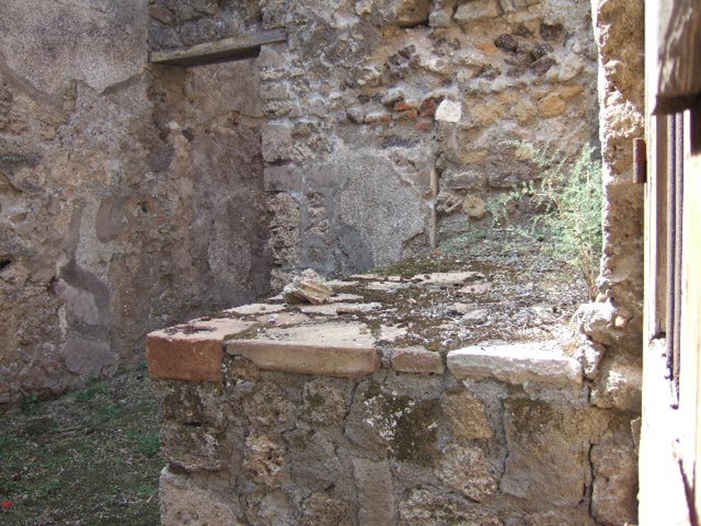 VII.7.5/14 Pompeii. September 2005.
Looking west from entrance doorway at VII.7.14, along north wall and hearth or bench in kitchen area (s).