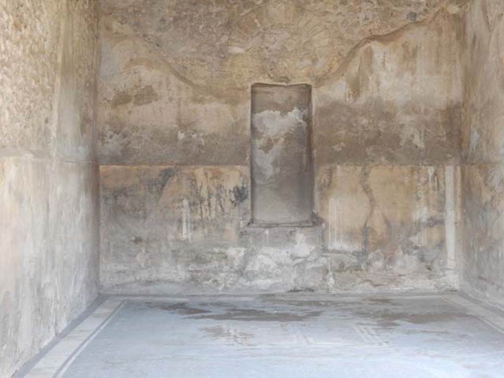 VII.7.5 Pompeii, May 2018. Triclinium (q), looking across flooring towards north wall with high niche. Photo courtesy of Buzz Ferebee.
According to Fiorelli –
“La sala da pranzo, o triclinio, ha due finestre, e due quadri.
Nel primo era rappresentato Triptolemo presso la biga dei serpenti, poggiato alla verga, che protende la mano a Proserpina per ricevere da lei le spighe del grano, mentre tiene accanto il canestro delle biade;
nel secondo sembra espressa la discesa di Venere protettrice di Pompei sul lido, ove fu poi fabbricata la citta, con la dea che stringe il lungo scettro d’oro ed ha il peplo sulle gambe, e che seduta sulle spire del Tritone porge la mano ad Amore, per discendere sulla spiaggia, ove una giovane donna, personificazione del luogo, la riceve facendo libazione su di un’ara inghirlandata.”
(trans: "The dining-room, or triclinium, has two windows, and two paintings.
In the first was seen Triptolemus near to the serpent’s chariot, resting on the rod, extending his hand towards Proserpina to receive from her the ears of grain, while holding the basket of fodder nearby;
In the second, it seemed to show the descent of Venus protector of Pompeii on the lido, where the city was built, with the goddess holding the long golden sceptre and having her legs covered, and sitting on the coils of the Triton holding her hand to Cupid, in order to descend to the beach, where a young woman, personification of the place, receives her by making a libation on the garlanded altar.”)
See Fiorelli, G. Guida di Pompei. 1877. (p.5).