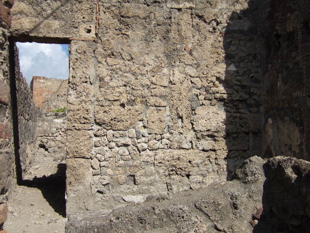 VII.7.11 Pompeii. September 2004. North wall with doorway to rear room, (behind entrance at VII.7.12 ), with corridor to rear.