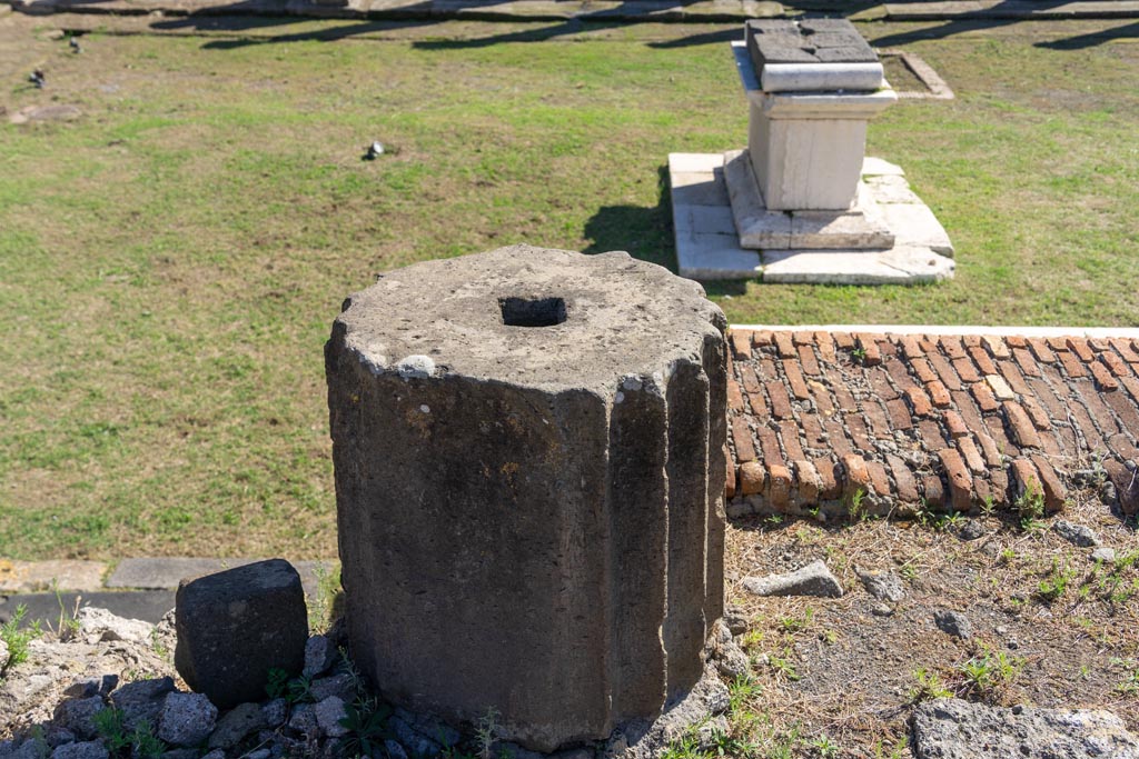 VII.7.32 Pompeii. October 2023. Detail of base of column, looking south on podium. Photo courtesy of Johannes Eber.