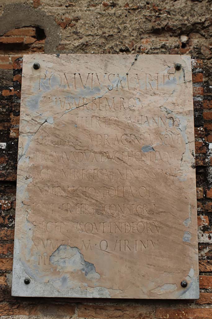 VII.9.1 Pompeii. March 2014. Portico 1. North end.
Plaque to Romulus, son of Mars, situated below niche between entrance and apsidal niche 4.
Foto Annette Haug, ERC Grant 681269 DÉCOR.