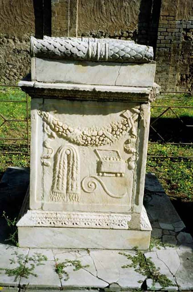 VII.9.2 Pompeii. July 2010. Altar. South side. According to Mau, the north and south sides have representations of ceremonial objects used in sacrificing. On this side is the napkin (mantele), the augural staff (lituus), and the box in which the incense was kept (acerra). See Mau, A., 1907, translated by Kelsey F. W. Pompeii: Its Life and Art. New York: Macmillan. (Page 107). Photo courtesy of Rick Bauer.